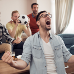 Prompt 5: A man cheering with his friends. One holds a soccer ball.