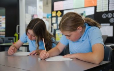 Two students focused on writing