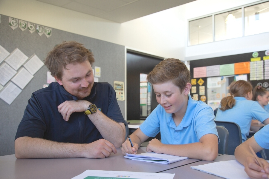 Teacher assisting student in his persuasive writing lesson