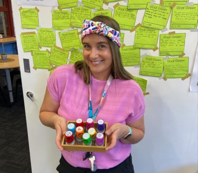 Seven Steps teacher standing in front of her writing goals display in her classroom.