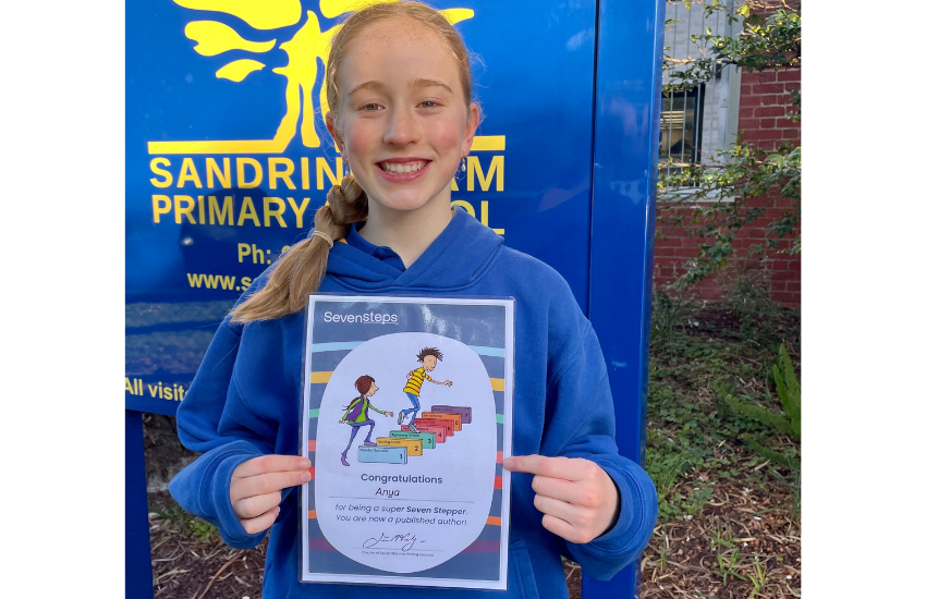 Year 3 student holding her writing certificate